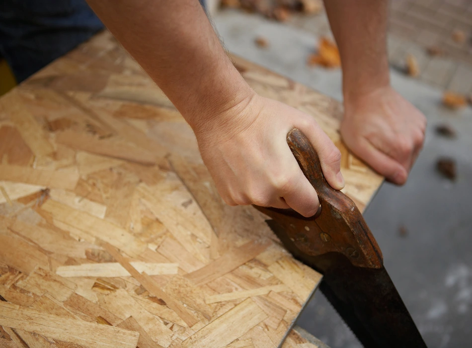 OSB Or Plywood: Best Workbench Top for Woodworking 7 OSB Or Plywood_ Best Workbench Top for Woodworking_Plywood Cutting Is Complicated_using a handsaw